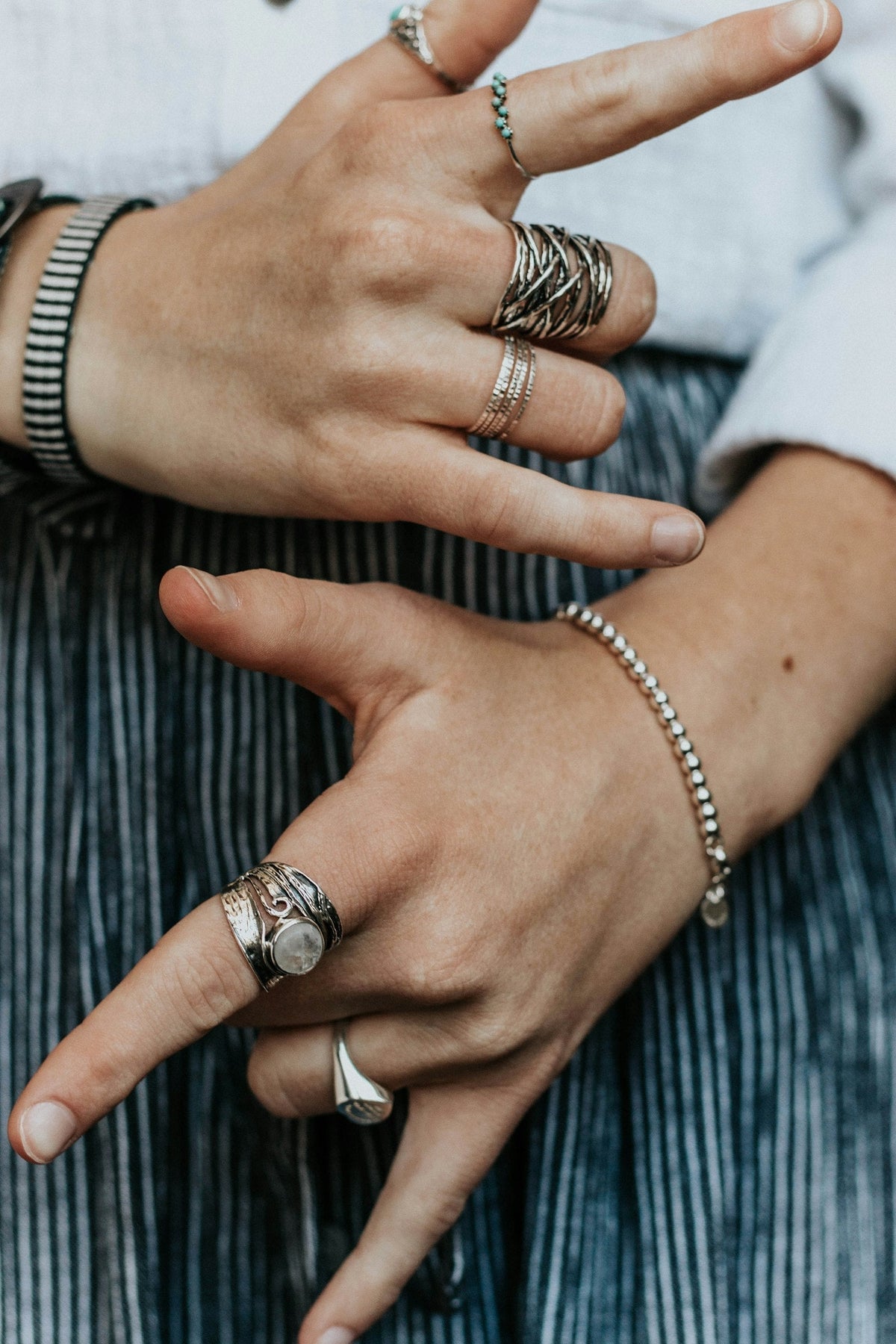 Hand wearing stacked silver and gold rings — the mixed-metal jewelry trend for fall 2026
