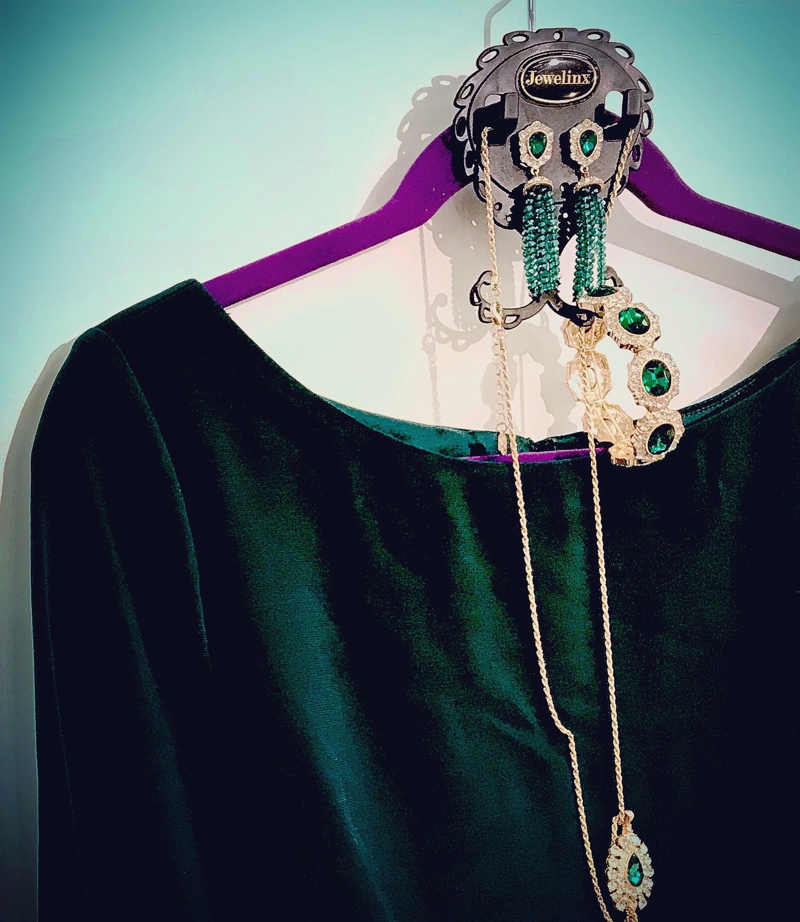 Emerald green jewelry styled with a green velvet dress on a Jewelinx hanging organizer
